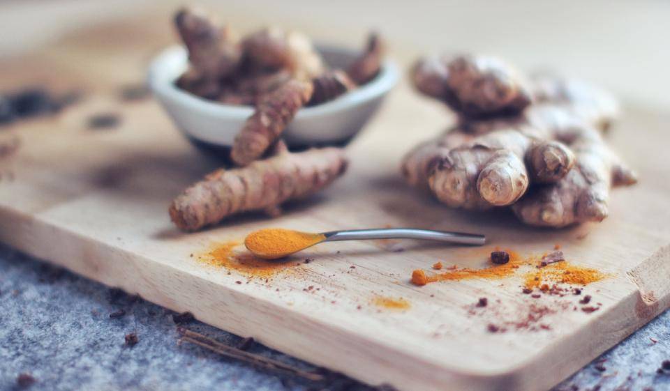 Ginger root and powdered turmeric on a cutting board